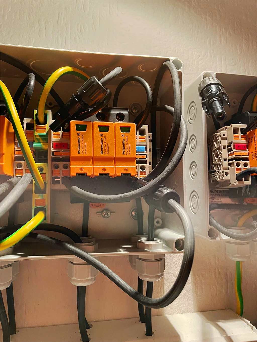 Detailansicht einer professionellen Elektroinstallation mit Verdrahtung, Schutzklemmen und farblich codierten Leitungen.